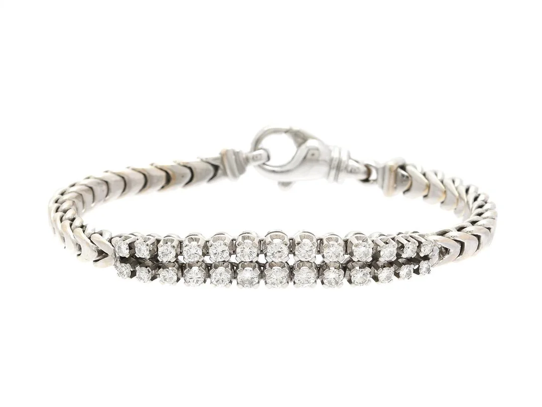 ARMBAND, 18K vitguld, 26 briljantslipade diamanter ca 1,50 ctv ca W/VS, längd 17 cm, vikt 26,9 g, mindre skada på en diamant. — Smycken/Armband — Kaplans