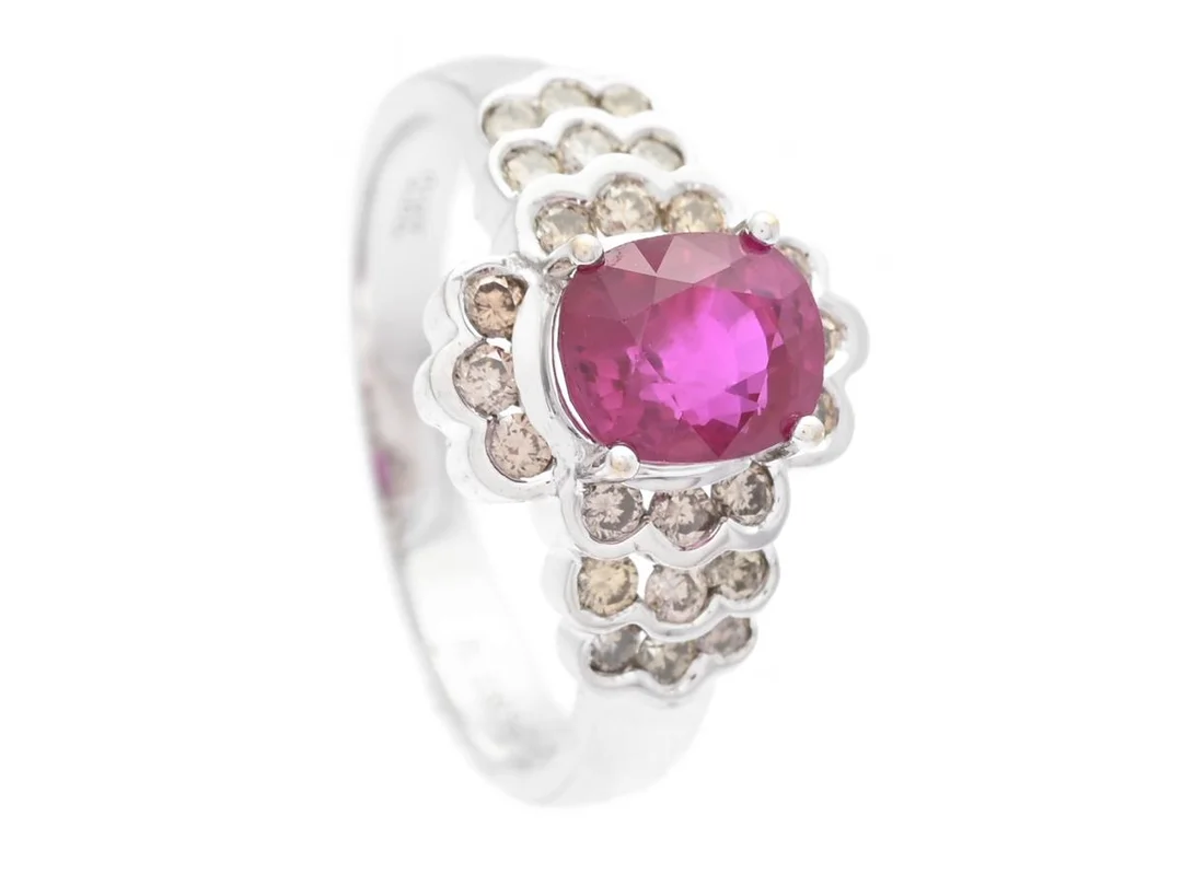 RING, 18K vitguld, ovalslipad rubin ca 1,53 ct, briljantslipade diamanter ca 0,41 ctv, ca Light Brown/SI-P, stl 16,25 mm, vikt 3,8 g, rubinen har små nagg, enstaka diamanter har nagg. — Smycken/Ring — Kaplans