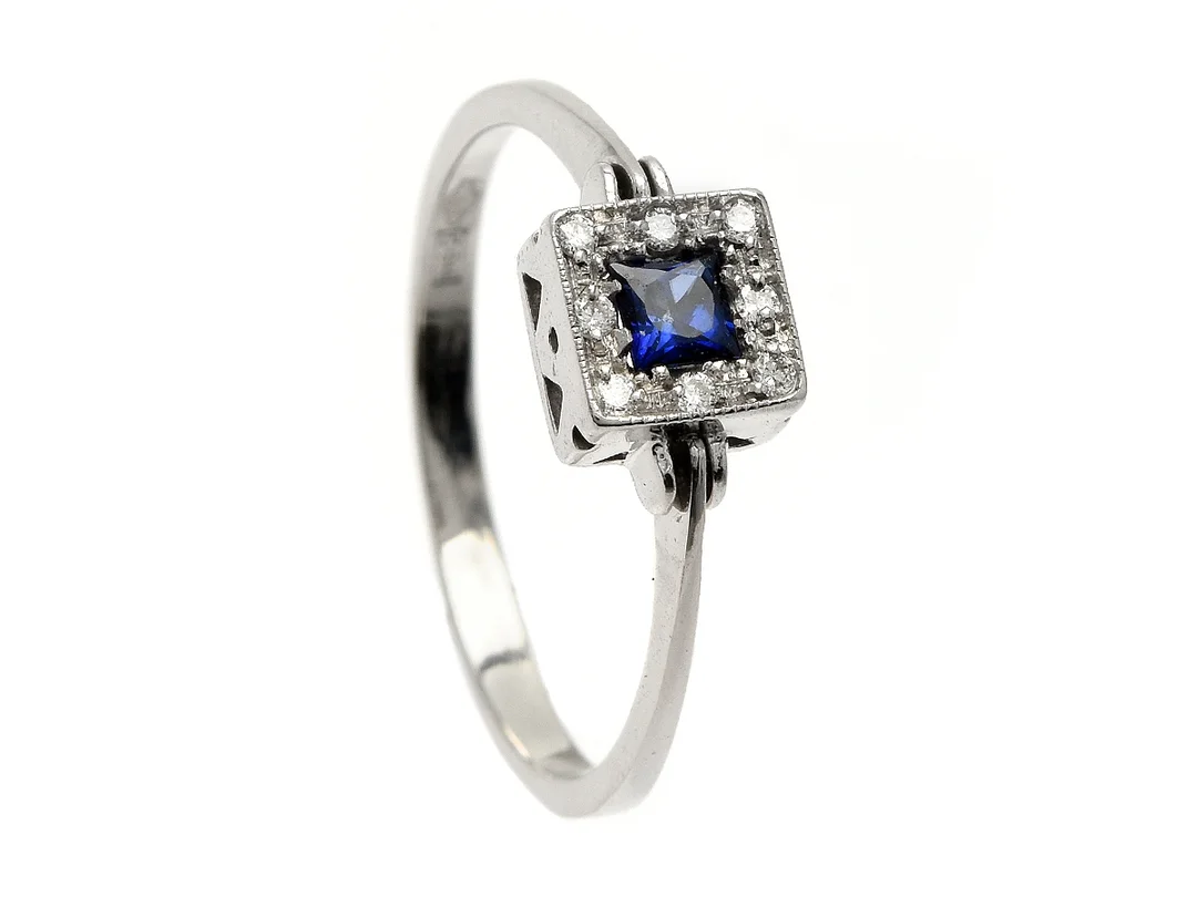 RING, 18K vitguld, blå safir ca 0,25 ct, 8 briljantslipade diamanter ca 0,08 ctv, stl 17,75 mm, vikt 2,3 g, nagg på safirens kulett. — Smycken/Ring — Kaplans