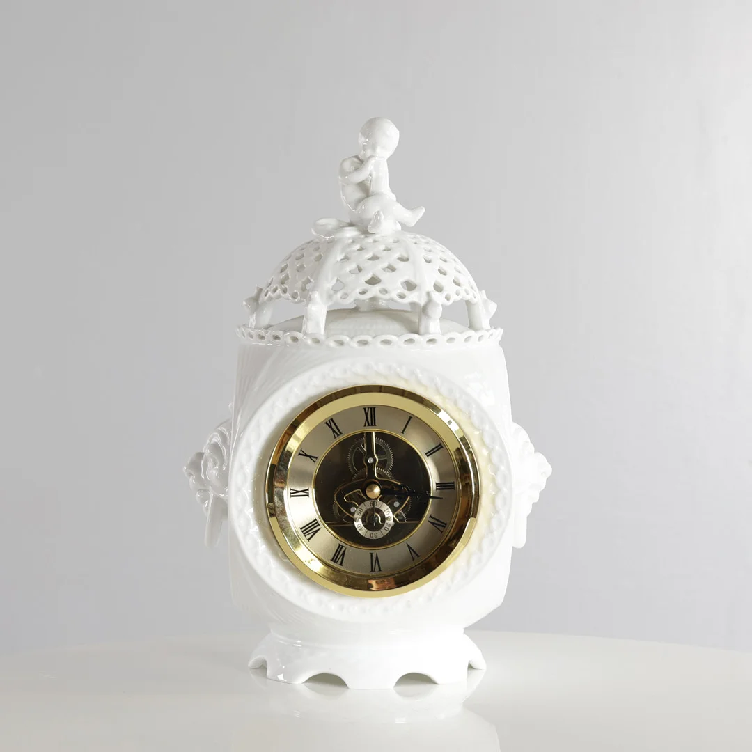 ARNOLD KROGH. “Helblonde”, sjældent urhus af hvid porcelæn, top med hvælvet blonde hvorpå dreng siddende med timeglas og seks kravlende snegle, herunder større snegl, sider med ringhanke i form af maskaroner, på hvælvet fodstykke. Udført og mærket hos Royal Copenhagen. — European — Woxholt Auktioner