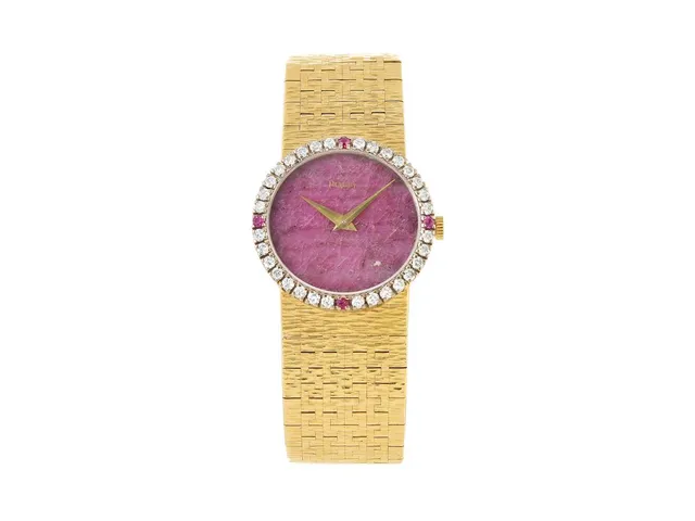 PIAGET, damur, 24 mm, Cal 9P2, Serie nr. 7802612, Ref nr. 9706 A6, Boett nr. 315156, 18K guld/vitguld, manuell, safirglas, urtavla i Rhodochrosite, briljantkrans med rubiner (32 st. briljanter (2 st. skadade), ca TW/VVS, ca 0,64 ctv + 4 st. rubiner (2 st. skadade), integrerad originallänk (förlängd), längd 162 mm, totalvikt 59,4 gram, ca 1975.