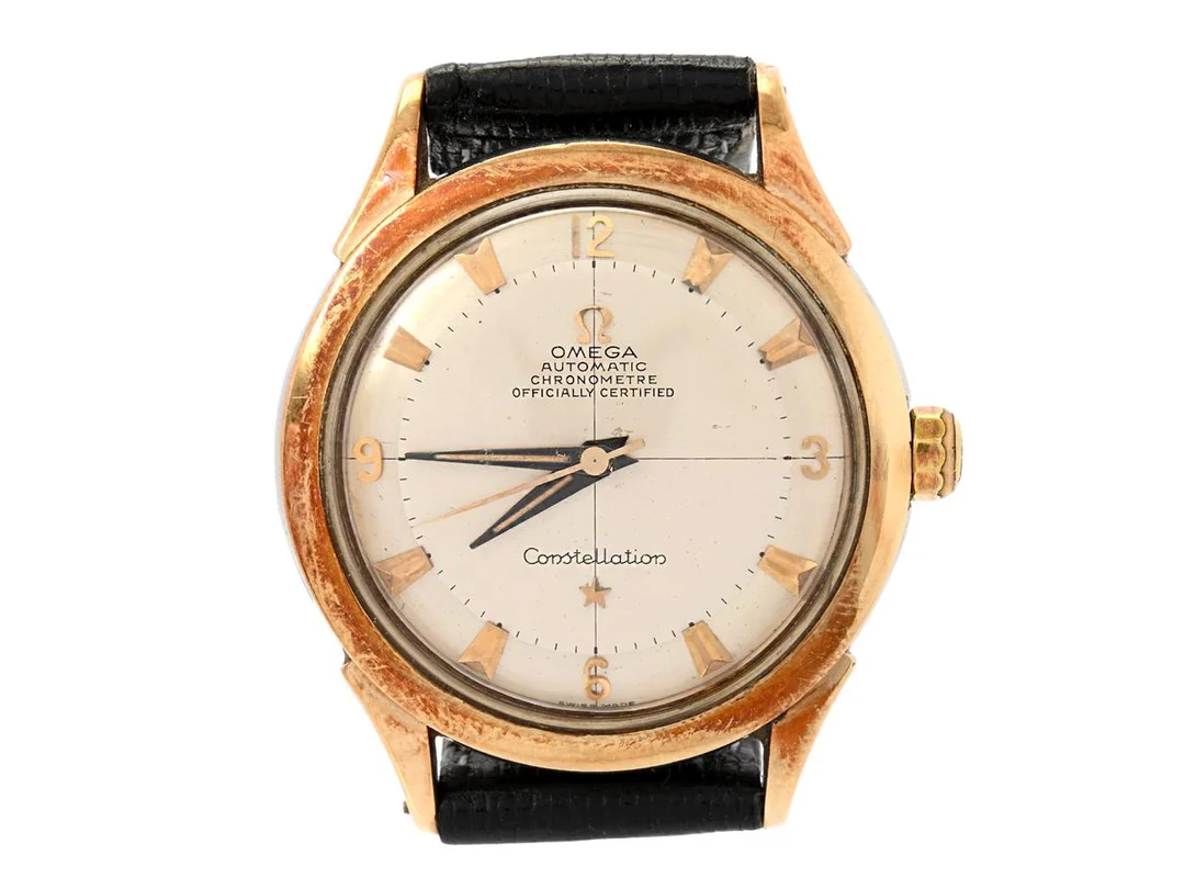 OMEGA, Constellation De Luxe, Chronometre, Cal 354, Serie nr. 13905552, Ref nr. KO 2652, Boett nr. 2652-13 SC, herrur, 35 mm, guld på stål, hammarautomat, plexiglas, utbytta/målade visare, skadad urtavla, läderband, ca 1953. — Klockor/Omega — Kaplans