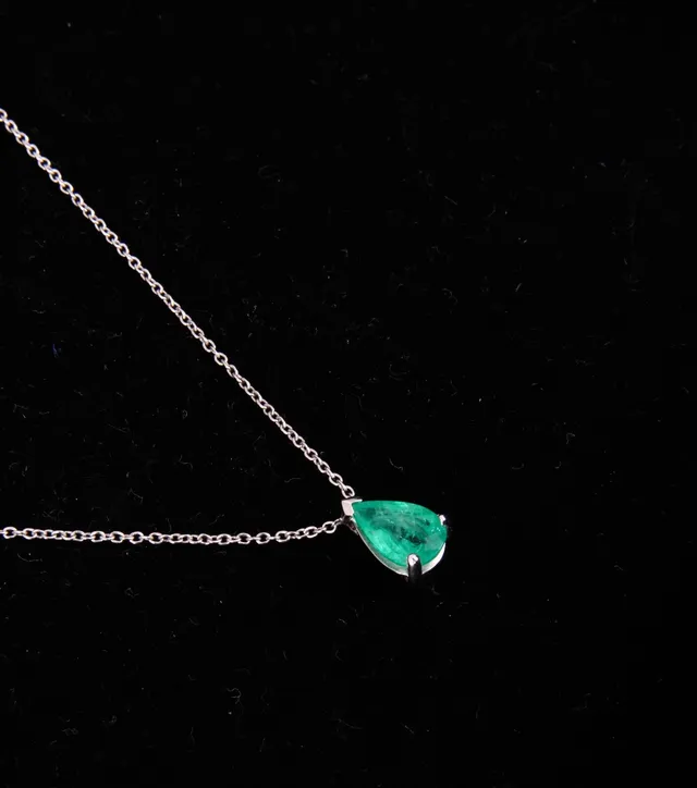 Emerald solitaire necklace of 18 kt. white gold with emerald of approx. 0.67 ct
