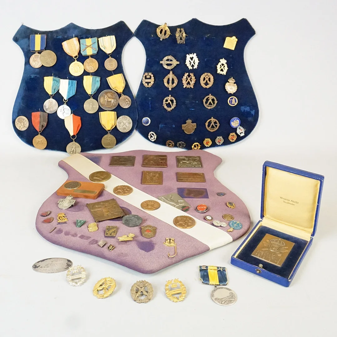 PARTI MEDALJER, varav 6 st i silver, samt nålmärken på märkessköldar. — Orders & Medals — Roslagens Auktionsverk