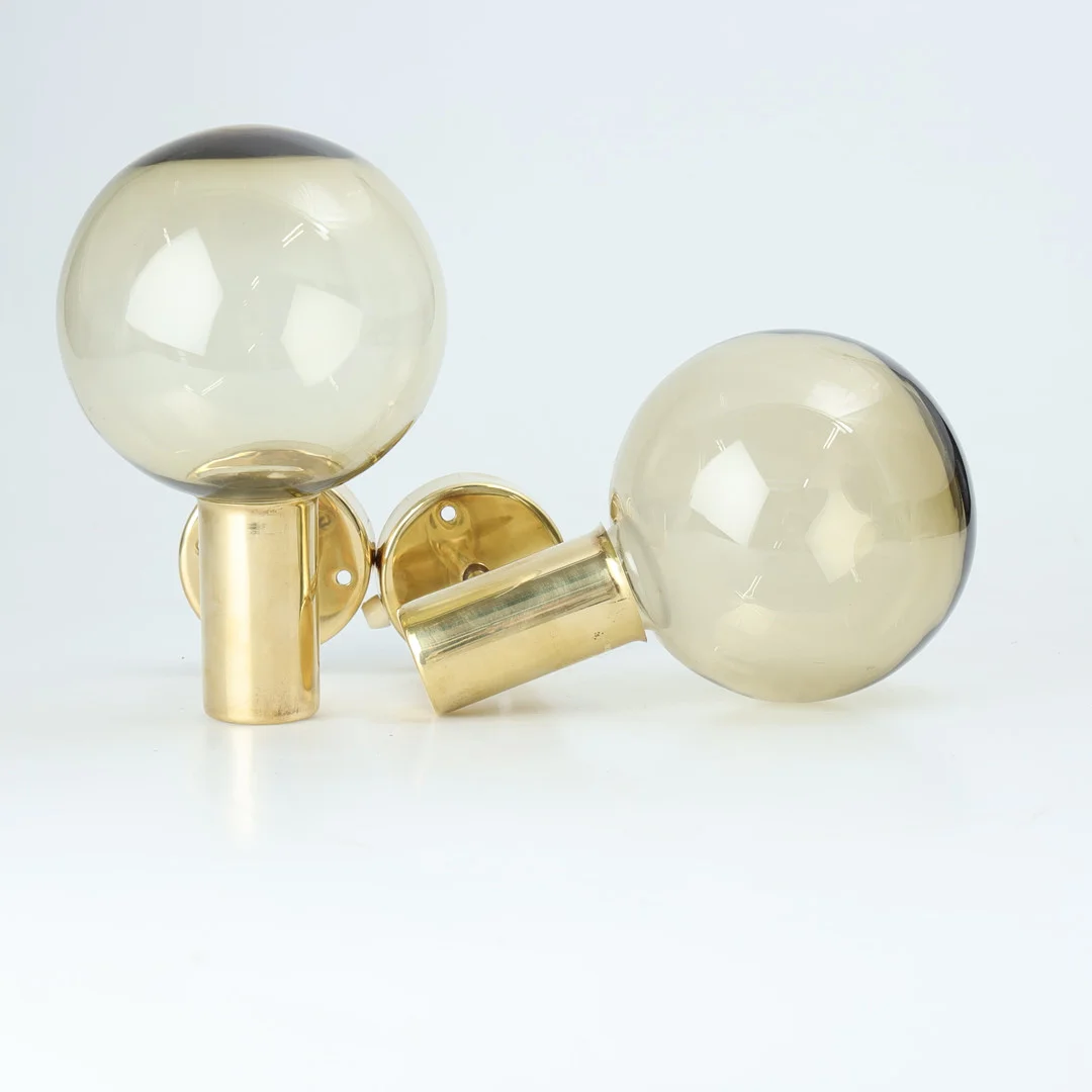 HANS-AGNE JAKOBSSON. VÄGGLAMPOR, ett par, mässing och rökglas, modell V 149, Markaryd, Sverige, 1960/70-tal, (2). — Wall Lights — Stockholms Auktionsverk Helsingborg