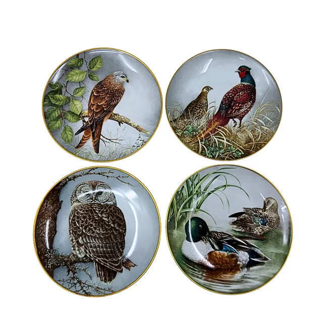 FRANKLIN MINT. VIER PORZELLAN-SAMMELTELLER MIT VERSCHIEDENEN TIERMOTIVEN UND GOLDRAND.