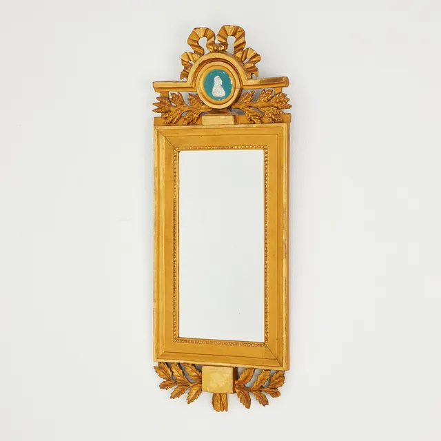 SPEGEL. Sengustaviansk, 1800-talets början, skuren dekor samt pastellage, gipsmedaljong, bandrosett, förgylld.