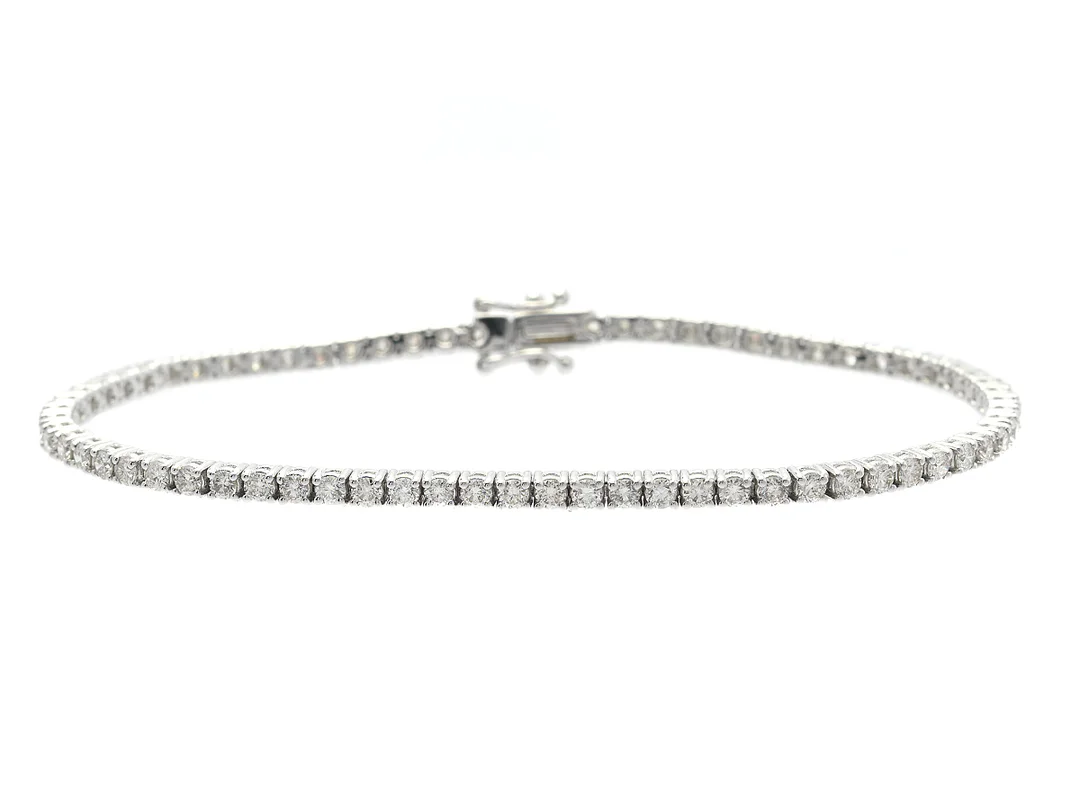 TENNISARMBAND, 18K vitguld, 70 briljantslipade diamanter ca 2,51 ctv, ca W-TCa(H-K)/VS-P, längd 17,5 cm, vikt 8,7 g, ett fåtal diamanter med nagg. — Smycken/Armband — Kaplans