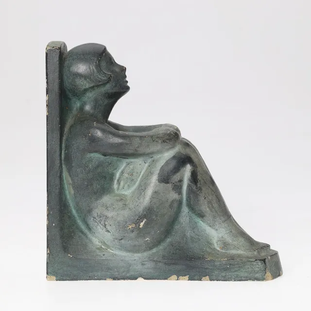 Skulpturel bogstøtte forestillende en siddende kvinde, bemalet gips, Art Deco, signeret, 1937.