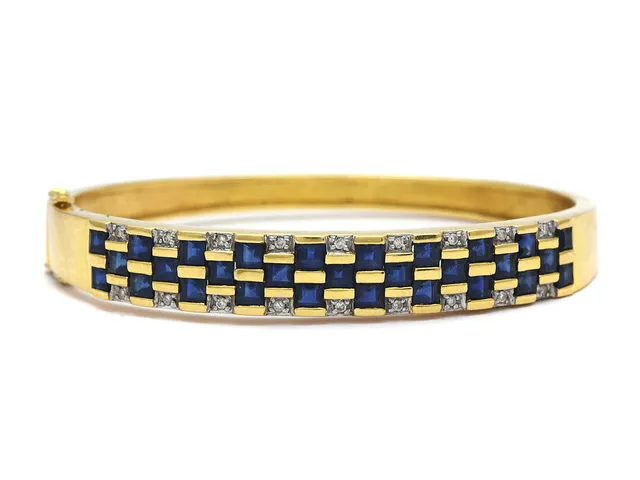ARMRING, 18K guld, blå safirer ca 4,35 ctv, 18 briljantslipade diamanter ca 0,18 ctv, 57x50 mm, vikt 26,9 g.