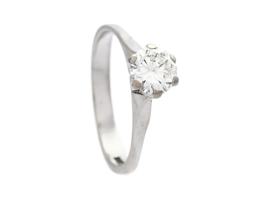 ENSTENSRING, 18K vitguld, briljantslipad diamant ca 0,79 ct, ca TW(F)/SI1, Juvelateljen Per-G Forslund, Malmö 1981, stl 17,5 mm, vikt 3,5 g, slitage, diamanten har flertalet skador vid rondisten. — Smycken/Enstensring — Kaplans