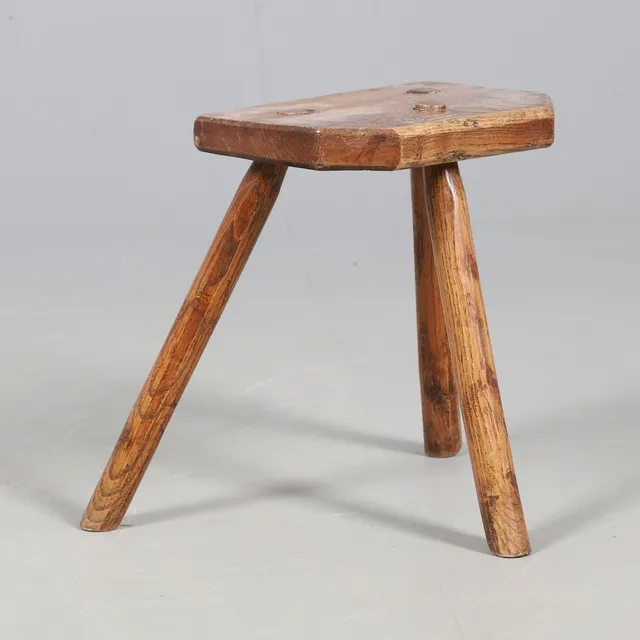 A PRIMITIVE ELM MILKING STOOL.