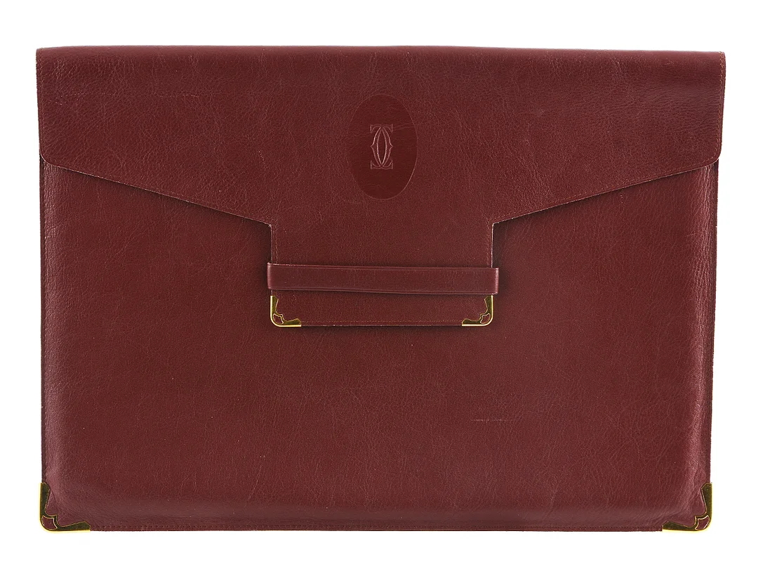 PORTFOLIO/MAPP, CARTIER, vintage, vinrött läder, hörn förstärkta med gulmetall, 33x24cm, visst slitage på insidan, — Accessoarer/Väskor — Kaplans
