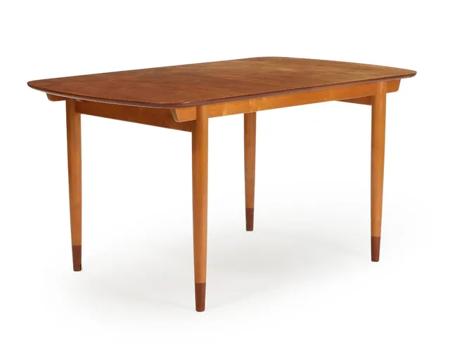 Dinning table with pull-out leaves, top of teak, frame and tapering legs of beech with shoes of teak. Desinged around 1953. Manufactured by Søren Willadsen, Vejen, Denmark. H. 73 cm. W. 83 cm. L. 140/220 cm.