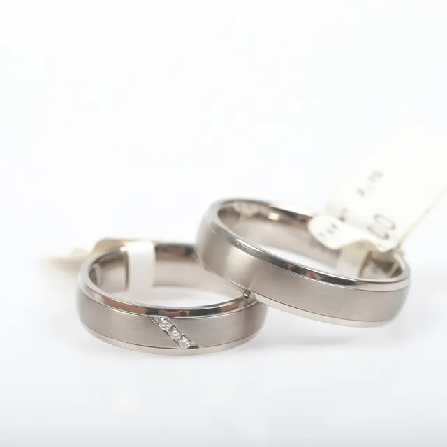 ALLIANSRINGAR, 2 stycken, titan med bl. a. briljantslipade diamanter, totalt 0,045 ct.