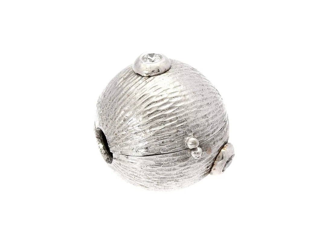 OLE LYNGGAARD, lås, 18K vitguld, arbetad yta, 3 briljantslipade diamanter 0,06 ctv, ca TW/VS, diameter 10,5 mm, vikt 3,2 g. — Smycken/Lås — Kaplans